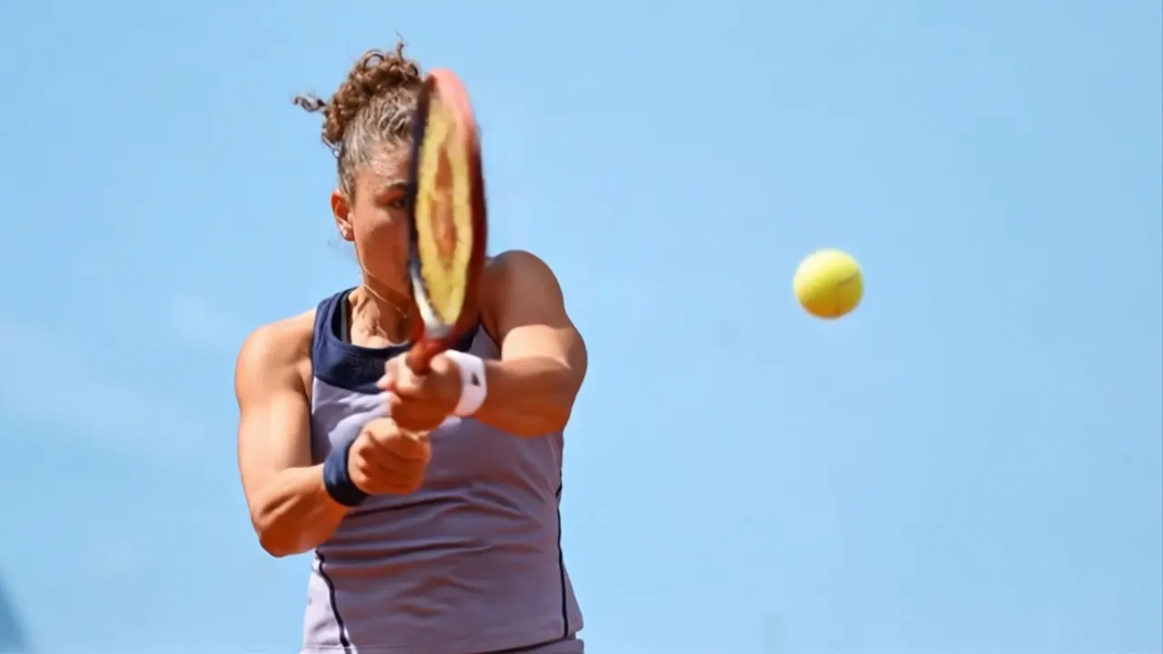 Tennista che colpisce la palla contro il cielo azzurro